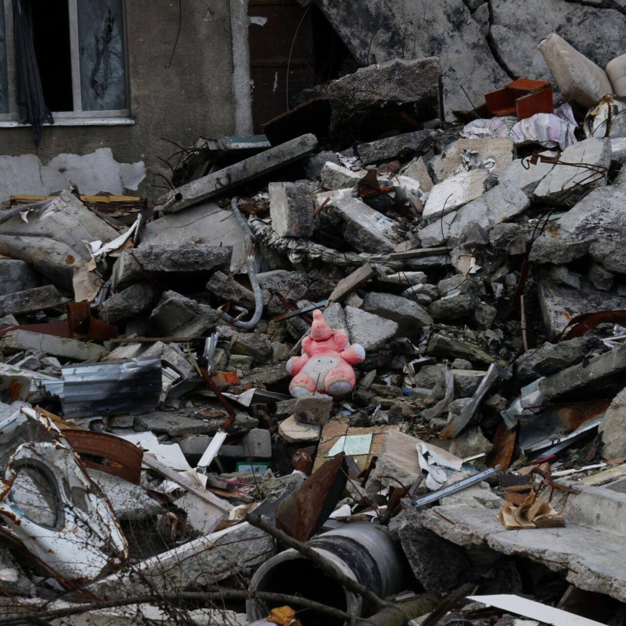 A pink stuffed animal sits amidst a pile of rubble in Ukraine.